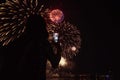 Silhouette of girl with smartphone on background of colorful fireworks Royalty Free Stock Photo