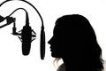 Silhouette of a girl with a studio microphone, radio presenter, singer and blogger, voice acting for films. Strong, black and Royalty Free Stock Photo