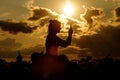 Silhouette of a girl at summer sunset. Stream music festival to the Internet via mobile phone