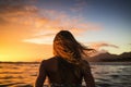 Silhouette of a girl in a swimsuit at sunset on the beach, Female surfer rear view in sea at sunset, Oahu, Hawaii, United States