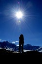 Silhouette of a girl on the top of the mountain against a sun and blue sky. Hiking. Caucasian ridge Royalty Free Stock Photo