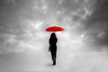 Silhouette of girl with umbrella in a dreamlike context - red umbrella with leaden sky - Royalty Free Stock Photo