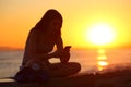 Silhouette of a girl using a smart phone at sunset