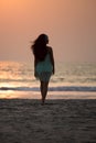 Silhouette girl walking along the beach at sunset Royalty Free Stock Photo