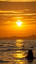 Silhouette of a girl in the water during a virant orange sunset in the sea, in Ao Nang, Thailand Royalty Free Stock Photo