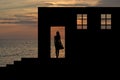 Silhouette of a girl in windowed openings of an old house ruins