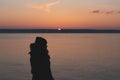 Silhouette of a girl in winter at sunset by the sea