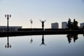 Silhouette girl or woman far away near water in city park. Female traveller posing near lake Royalty Free Stock Photo