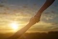 Silhouette of giving a help hand, hope and support each other over sunset background Royalty Free Stock Photo