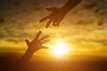 Silhouette of giving a help hand, hope and support each other over sunset background Royalty Free Stock Photo