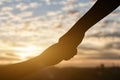 Silhouette of giving a help hand, hope and support each other over sunset Royalty Free Stock Photo