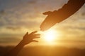 Silhouette of giving a helping hand, hope and support each other over sunset Royalty Free Stock Photo
