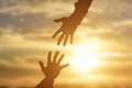 Silhouette of giving a helping hand, hope and support each other over sunset Royalty Free Stock Photo