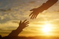 Silhouette of giving a helping hand, hope and support each other over sunset Royalty Free Stock Photo