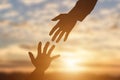 Silhouette of giving a helping hand, hope and support each other over sunset Royalty Free Stock Photo