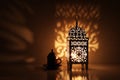 Silhouette of glowing Moroccan ornamental lantern with bronze tea cup. Decorative golden shadows. Greeting card