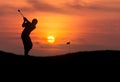 Silhouette golfer hitting golf ball in sunset Royalty Free Stock Photo