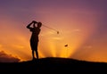 Silhouette golfer hitting golf ball at sunset Royalty Free Stock Photo