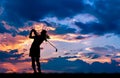 Silhouette golfer playing golf at beautiful sunset