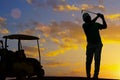 silhouette golfer playing golf with golf cart during beautiful sunset Royalty Free Stock Photo