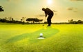 Silhouette golfer showing happiness when win in game , white golf ball on green grass with blur background. Royalty Free Stock Photo