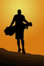 Silhouette of golfer walking away with golf bag into the sunset Royalty Free Stock Photo