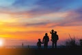 Silhouette of Grandfather grandmother granddaughter and grandchild looking sun down and walking on the beach evening sunset