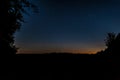 grass in a field and trees in the forest just after sunset under a starry sky with stars Royalty Free Stock Photo