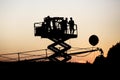 Silhouette of group of cameramen on the lift at a summer event