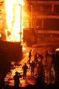 Silhouette of a group of firemen taking a water break while dousing a fiery fuel tanker