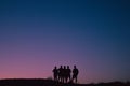 Silhouette of a group of five friends standing in front a pink sunset Royalty Free Stock Photo