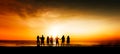 Silhouette of group of friends are having fun, having fun on the beach in the evening sunset Royalty Free Stock Photo