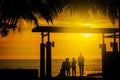 Silhouette, a group of happy children, admiring the beautiful yellow sea sunset. palm leaves. hotel in Thailand. summer. Royalty Free Stock Photo