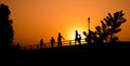 Silhouette group of people in activity exercise, walking, running on the walkway at riverside, and beautiful sunset sky.