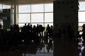 Silhouette of group of people queuing, waiting for turn, for boarding in the modern airport in Barcelona, Catalonia Royalty Free Stock Photo