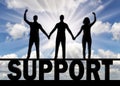 Silhouette of a group of people of three people holding hands stand on the word support Royalty Free Stock Photo