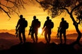 Silhouette of a group of soldiers standing on top of a mountain during sunset