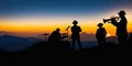 Silhouette of a group of three folksong musicians playing music in the grassland with the morning sun on top of a mountain