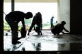 Silhouette group of workers build the cement floor in the house under construction