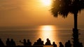 Silhouette of group of young people, friends, team standing enjoying together see orange sky at sunset over sea ocean Royalty Free Stock Photo