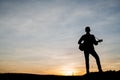 Silhouette of guitar player jump on stone Royalty Free Stock Photo