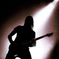 Silhouette of guitarist with falling light behind