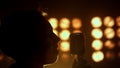 Silhouette guy performing song in nightclub closeup. Unknown vocalist singing.