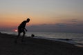 Silhouette of guy on the seashore at sunset plays the ball. Unity with nature and filling with vitality. Summer concept