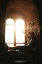 Silhouette of a guy sitting on the window in a Genoese fortress in Sudak Crimea Stone walls of an ancient castle Royalty Free Stock Photo