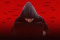Silhouette of a hacker in the hood with a laptop, against the backdrop of digital technology terms. Concept: digital data theft,