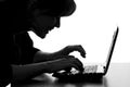 Silhouette of a hacker typing on the keyboard of laptop Royalty Free Stock Photo