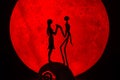 The silhouette of Halloween Ghost couple decorations.There`s a red full moon in the background. Halloween horror concept