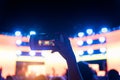 Silhouette of hand with camera or mobile phone recording video in concert music festival Royalty Free Stock Photo