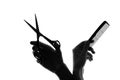 Silhouette hand with a comb and scissors Royalty Free Stock Photo